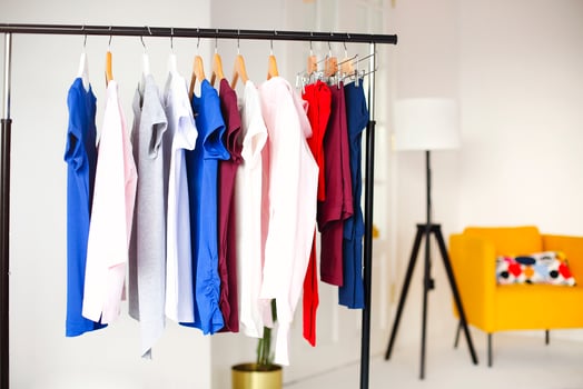Colorful clothes hanging on rack in room photo