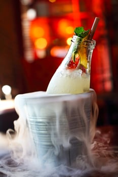 Lemonade serviced in the bottle with mint in the bucket with dry ice photo