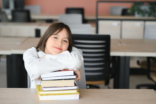 Teen girl studying with textbook writing essay learning in classroom. photo