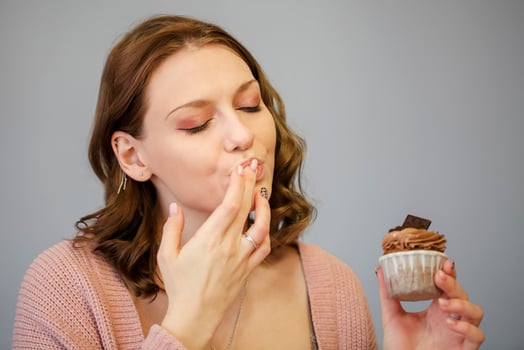 Happy woman eating cupcakes photo