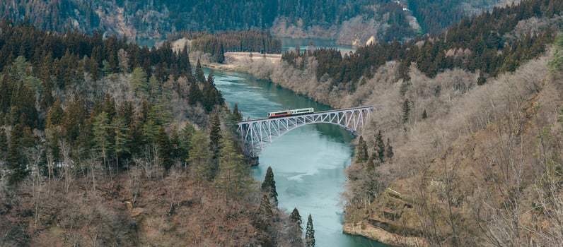 Panoramic View of Japan local train with Tadami river and bridge. Tadami Railway Line in The Valley at Mishima Machi, Aizu, Fukushima Prefecture, Japan. Landmark and iconic spot for tourist attraction photo