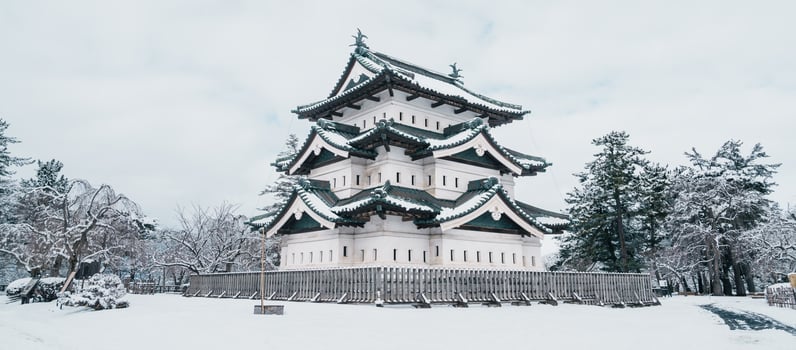 White Hirosaki Castle or Takaoka Castle with snow in winter, hirayama style Japanese castle located in Hirosaki city, Aomori Prefecture, Tohoku, Japan. Landmark for tourist attraction. Japan travel photo
