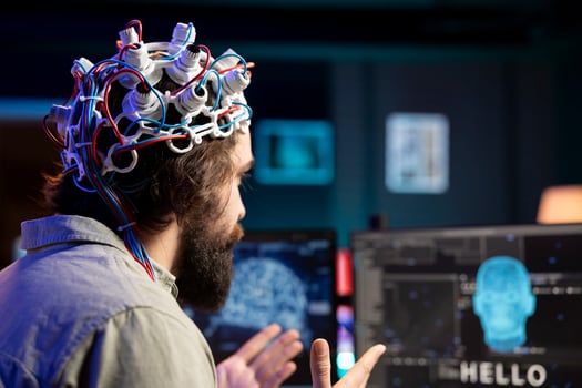 Software developer using EEG headset device translating thoughts into PC commands using brainwave signals. IT professional controlling computer functions using mind, helped by technology, close up photo