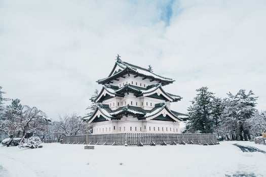 White Hirosaki Castle or Takaoka Castle with snow in winter, hirayama style Japanese castle located in Hirosaki city, Aomori Prefecture, Tohoku, Japan. Landmark for tourist attraction. Japan travel photo