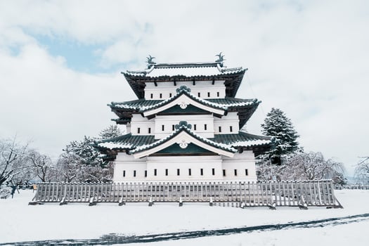 White Hirosaki Castle or Takaoka Castle with snow in winter, hirayama style Japanese castle located in Hirosaki city, Aomori Prefecture, Tohoku, Japan. Landmark for tourist attraction. Japan travel photo