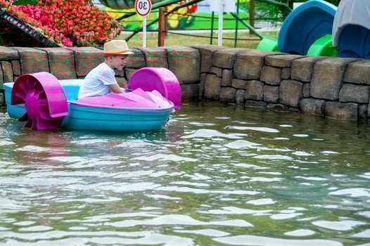Kid playing rowing water paddle boat. Soft focus. . High quality photo