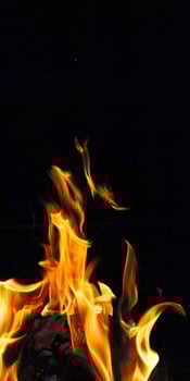 Outdoor campfire. Campfire for cooking food on a camping trip. Fire on a black background. Vertical photo
