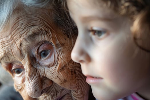 An elderly woman, eyes sparkling, shares a heartfelt story with her young granddaughter photo