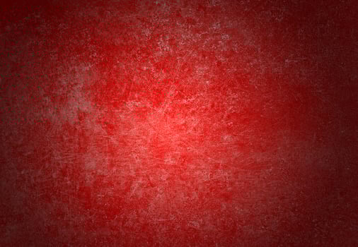 The red concrete wall is scratched, blank, and has shadows. photo
