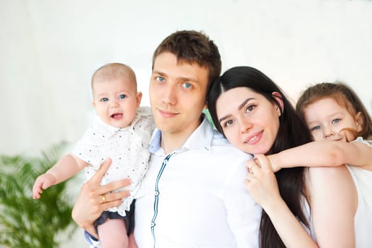 Happy young parents with their adorable little kids at home photo