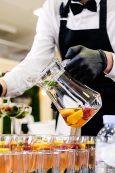 Bartender Pouring Fresh Fruit Cocktail in Glasses photo
