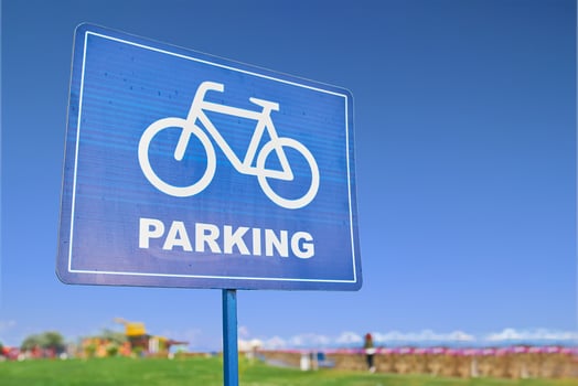 A blue traffic sign featuring a bicycle symbol against a backdrop of the sky, grass, and plants. The font is bold and easy to read, emphasizing the importance of sharing the road with bicyclists photo