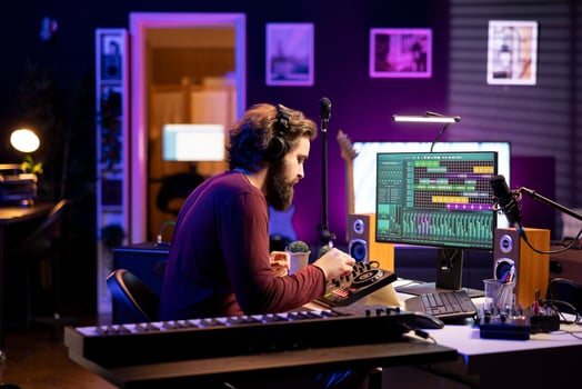 Audio producer twisting pre amp knobs on console to edit music, recording tunes with daw software on pc in home studio. Artist composing soundtracks with stereo gear and amplifier. photo