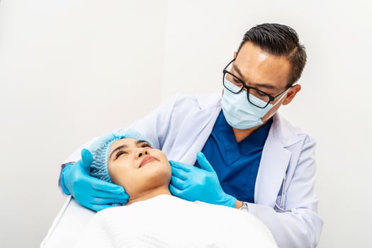 Cosmetic Surgeon Examines Beautiful Woman's Face, Touches it with Gloved Hands, Inspecting Wrinkles for Future Facelift Surgery, Face skin check before plastic surgery, Doctor checks a skin photo