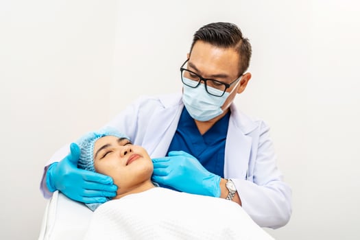 Cosmetic Surgeon Examines Beautiful Woman's Face, Touches it with Gloved Hands, Inspecting Wrinkles for Future Facelift Surgery, Face skin check before plastic surgery, Doctor checks a skin photo
