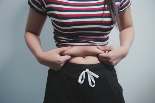Women body fat belly. Obese woman hand holding excessive belly fat. diet lifestyle concept to reduce belly and shape up healthy stomach muscle. photo