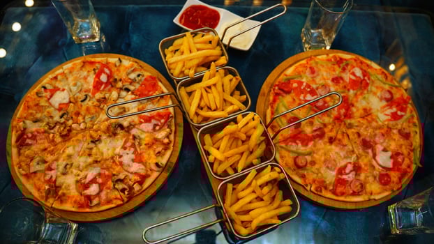 Two Pizzas and French Fries on a Table photo