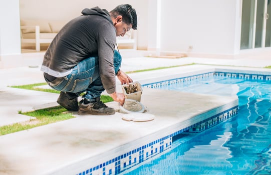 Man cleaning swimming pool filter basket. Person cleaning garbage filter basket for swimming pool photo
