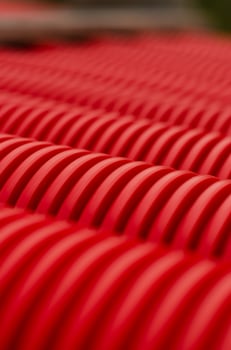 Close-up of flexible red hoses for laying power cables in the ground. High quality photo