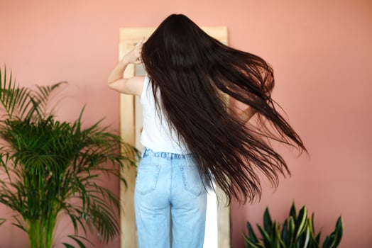 Stylish young woman near mirror and plants photo