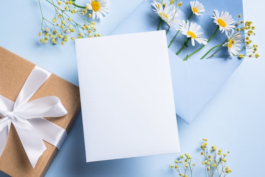 Greeting or invitation card, gift box and chamomile flowers photo
