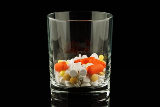 Lots of pills in a glass photo