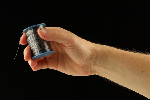 Coil of thin steel iron wire in hand photo