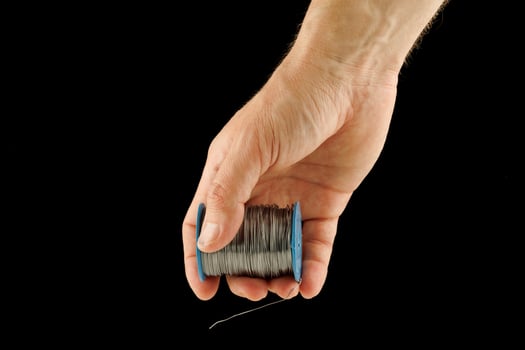 Coil of thin steel iron wire in hand photo
