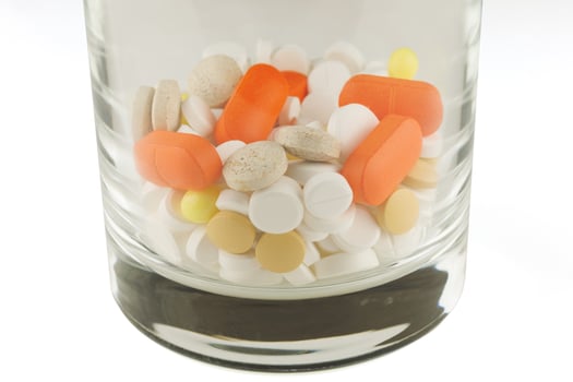 Lots of pills in a glass photo