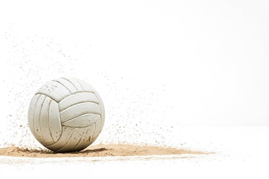 Volleyball crashing into sand, white background photo
