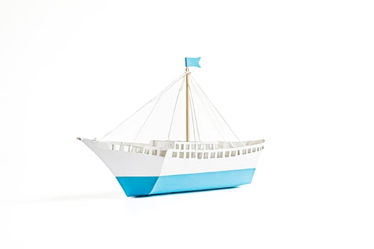 White paper ship with blue details isolated on white background photo