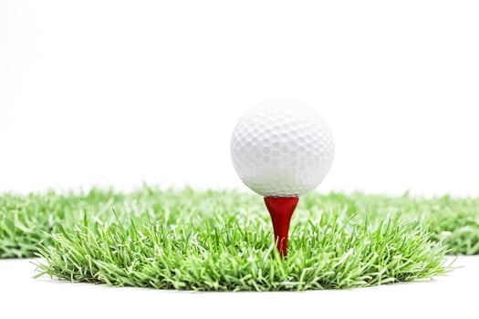 Golf ball on a tee in grass photo