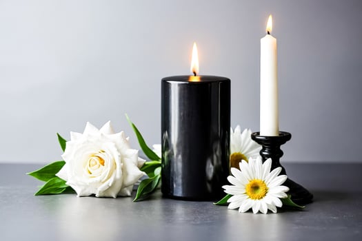 Black Candle, White Rose, and Daisy on Grey Background photo