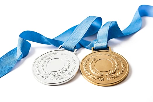 Gold and silver medals with blue ribbons on a white background photo