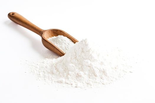 Wooden Scoop and Flour Pile on White Background photo