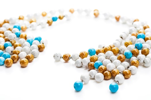 White, Gold, and Blue Beaded Necklace on White Background photo