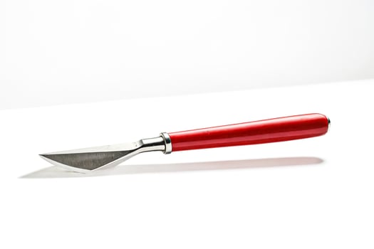 Red handled knife isolated on white background photo