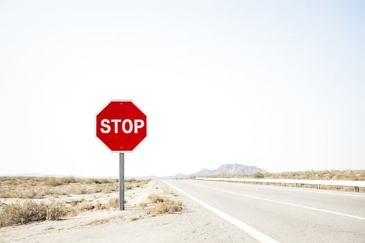 Stop sign on a desert road photo