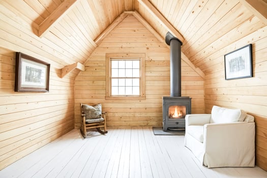 Cozy cabin living room with wood walls, white floors, fireplace and rocking chair photo