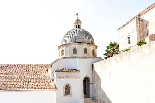 Church dome and roof with stone tiling in a sunny day photo