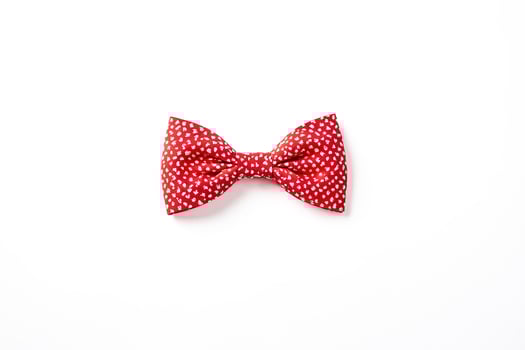 Red bow tie with white polka dots on a white background photo