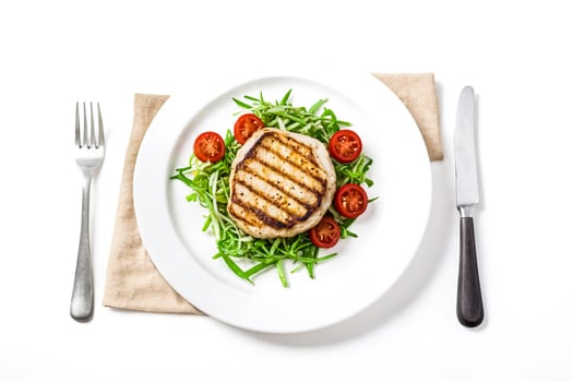 Grilled pork chop with salad on a white plate photo