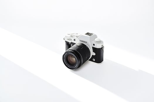 White Camera with Black Lens on White Background photo