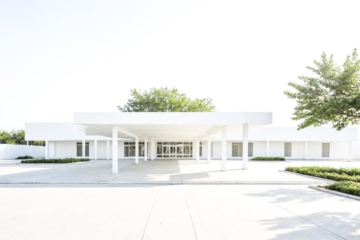 Minimalist White Building with Canopy and Lush Green Trees photo