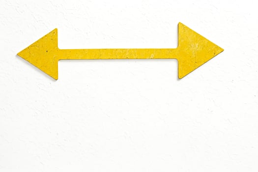 Yellow Double Arrow on White Cracked Wall photo