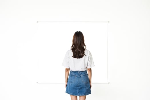 Woman in White T-Shirt and Denim Skirt Facing Blank Canvas photo