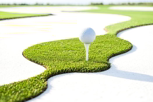 Golf Ball on Tee on Green Grass photo