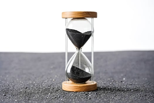 Hourglass with Black Sand on Black Surface photo