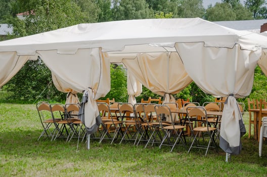 Summer tent with chairs stacked outside for celebration photo