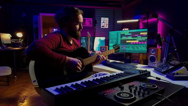 In home studio, music engineer practices acoustic guitar and writes songs, entertaining himself with amplification devices and musical tools. Skilled musician performer producing a tune. Camera A. photo